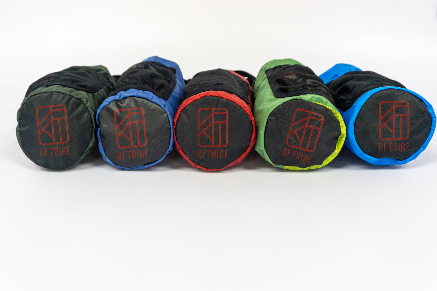 The image is of 5 Bottle holder bags laid down with the bottom of the bag on display, the bottom on the bag is circular and has the Retribe logo embroidered on in orange.